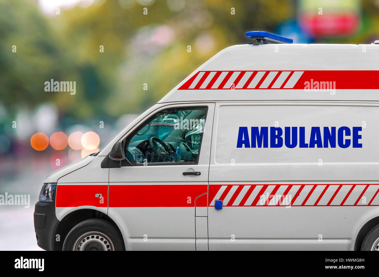 Ambulance service van driving fast on street Stock Photo