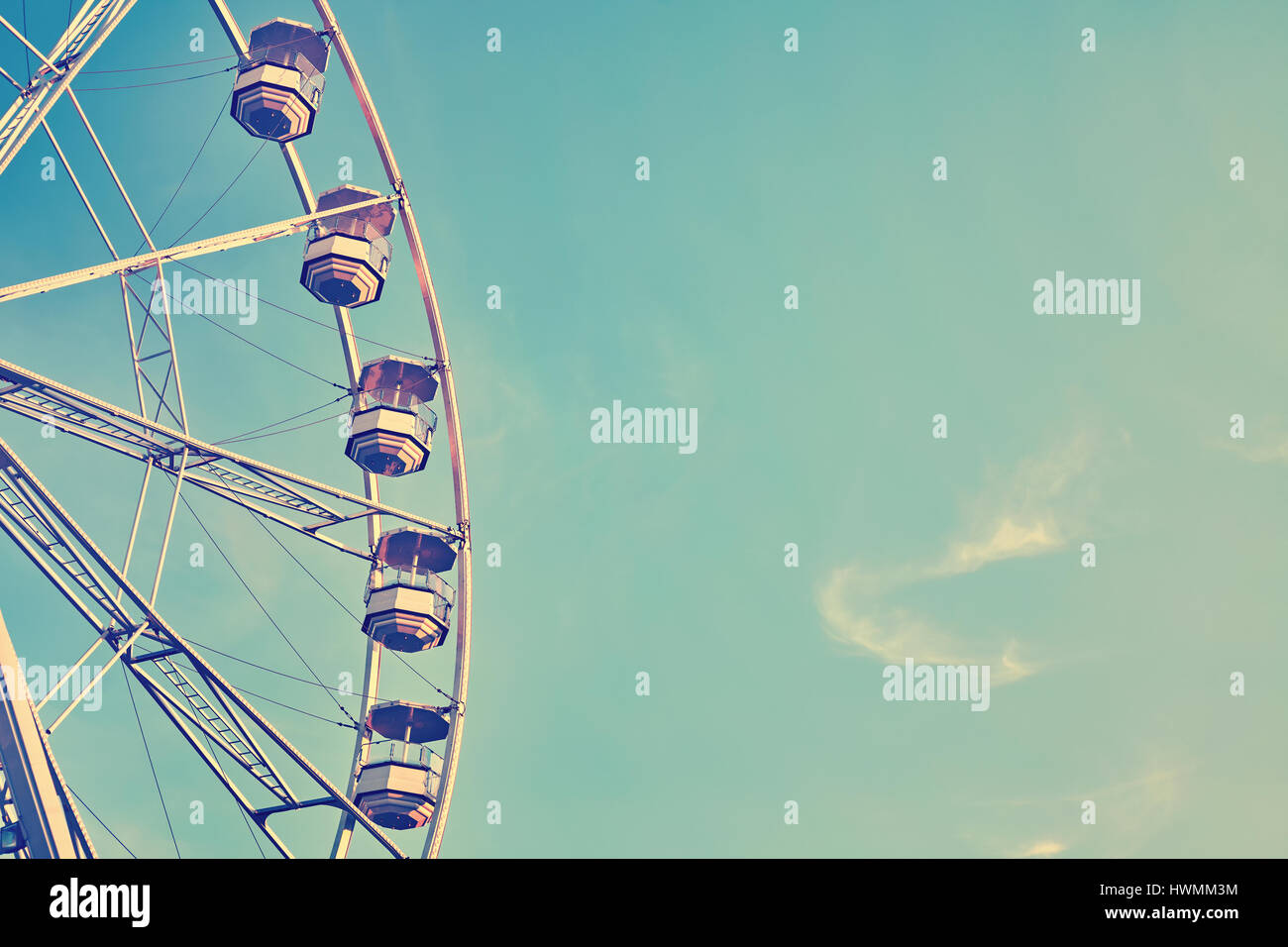 Vintage stylized picture of a ferris wheel against blue sky, copy space. Stock Photo