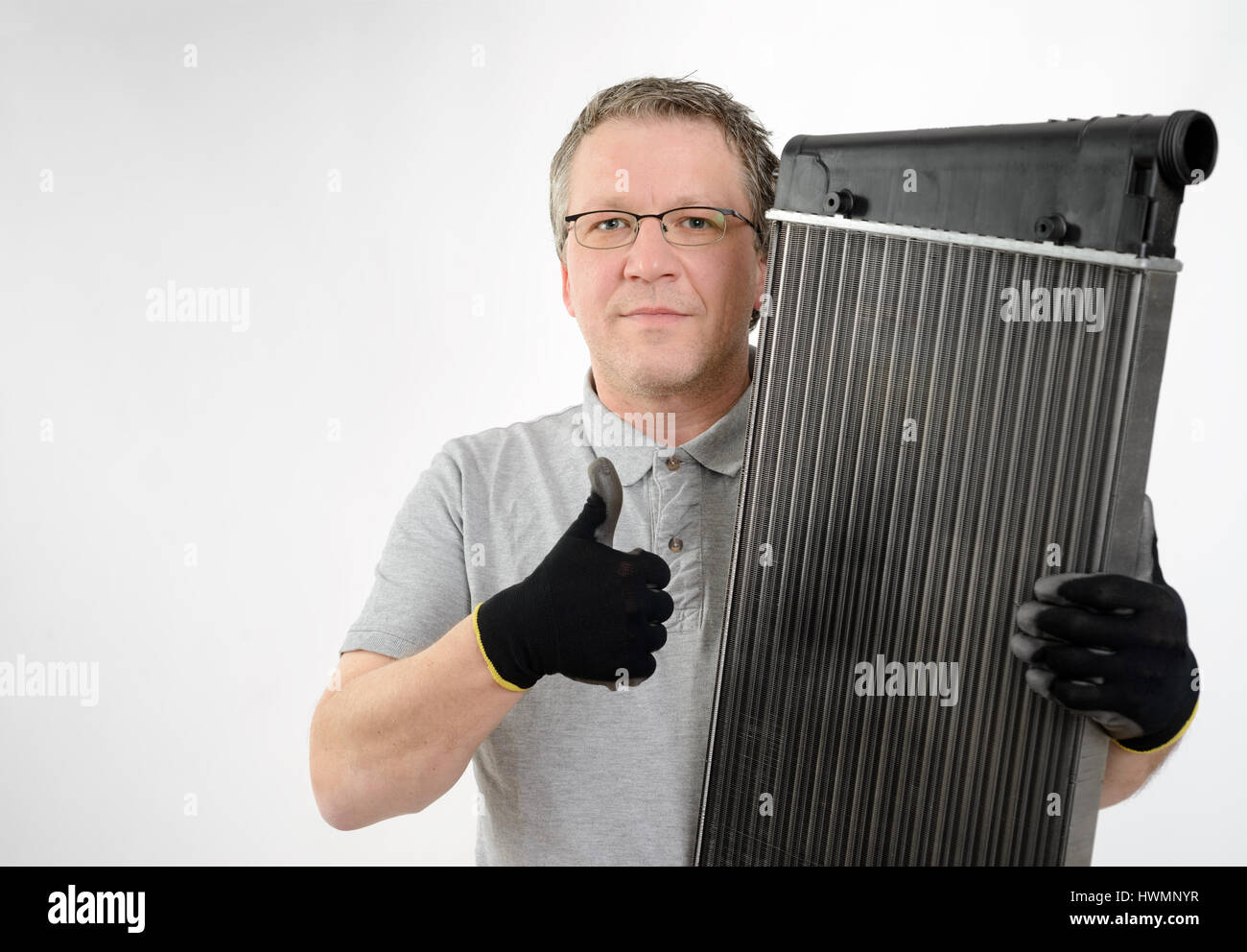 Car cooler, heat exchanger in the hand of the mechanic, workshop, service, repair Stock Photo