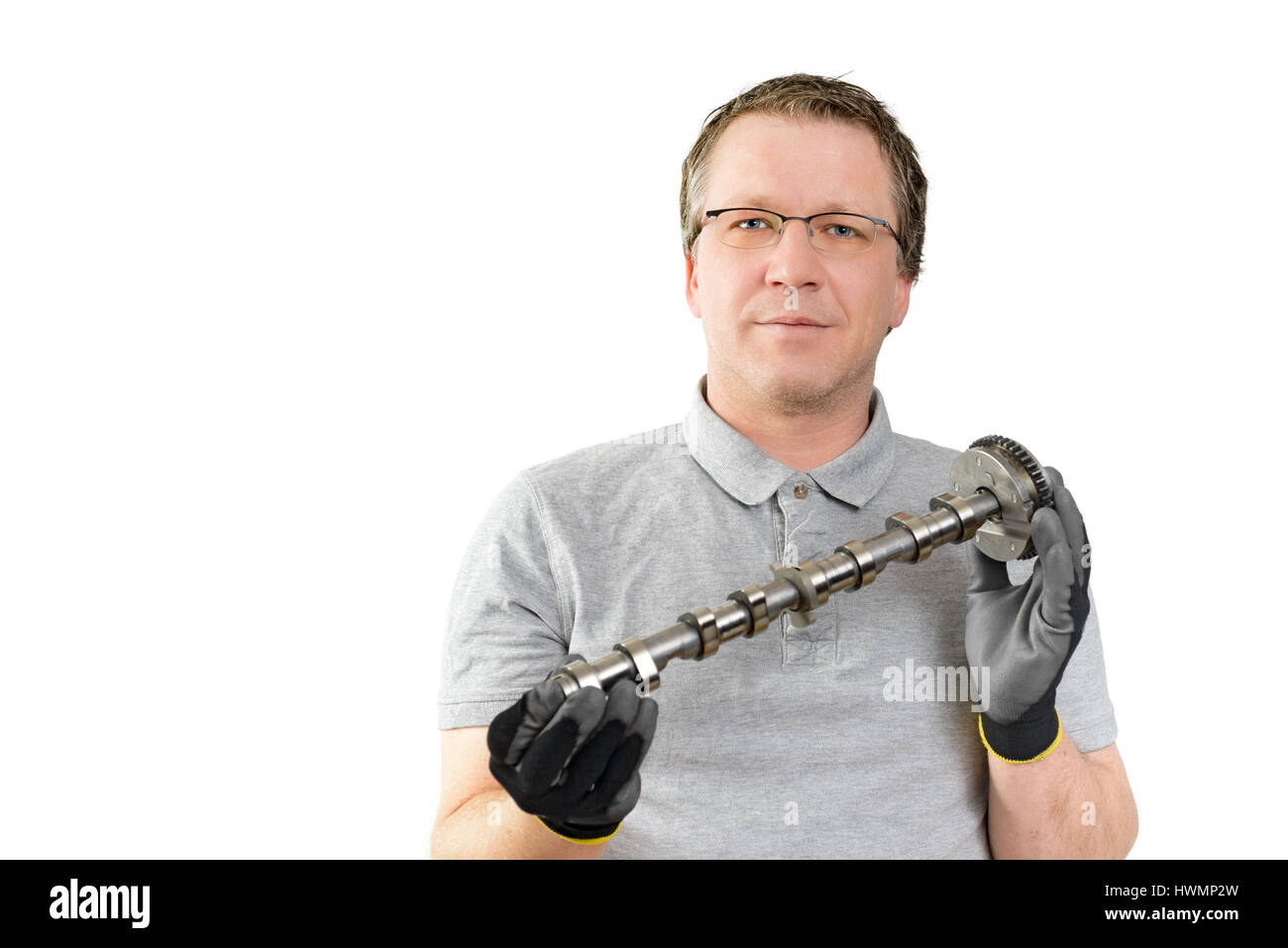 Car mechanic keeps the camshaft ready. New car parts for service and repair Stock Photo