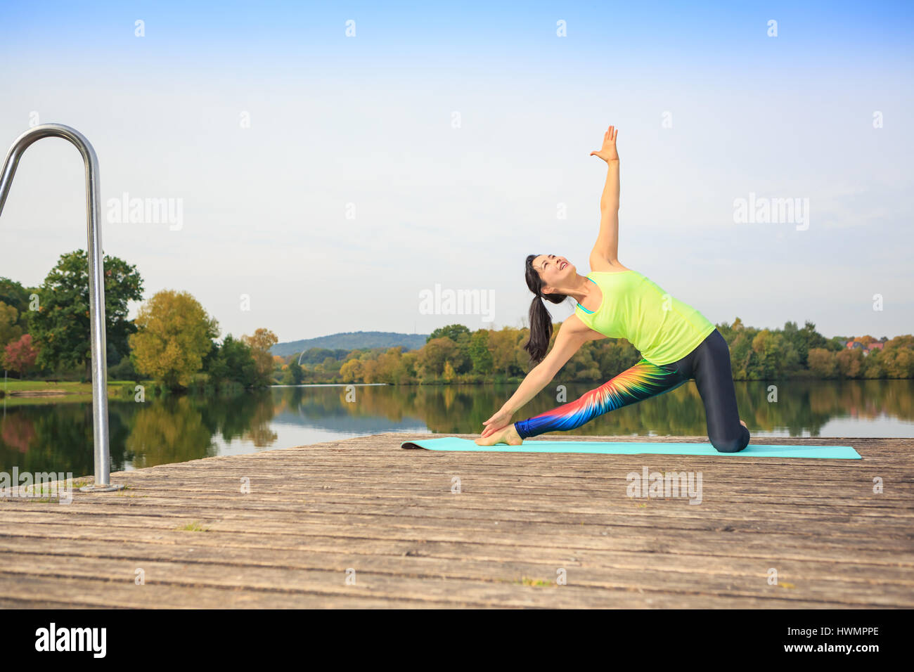 young woman doing yoga exercise at a lake Stock Photo