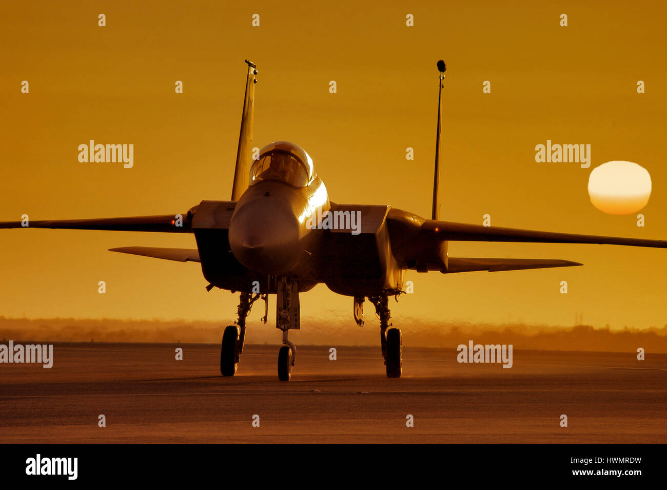 Golden orb of the sun sets behind a McDonnell Douglas F-15 Strike Eagle, Bahrain. Stock Photo