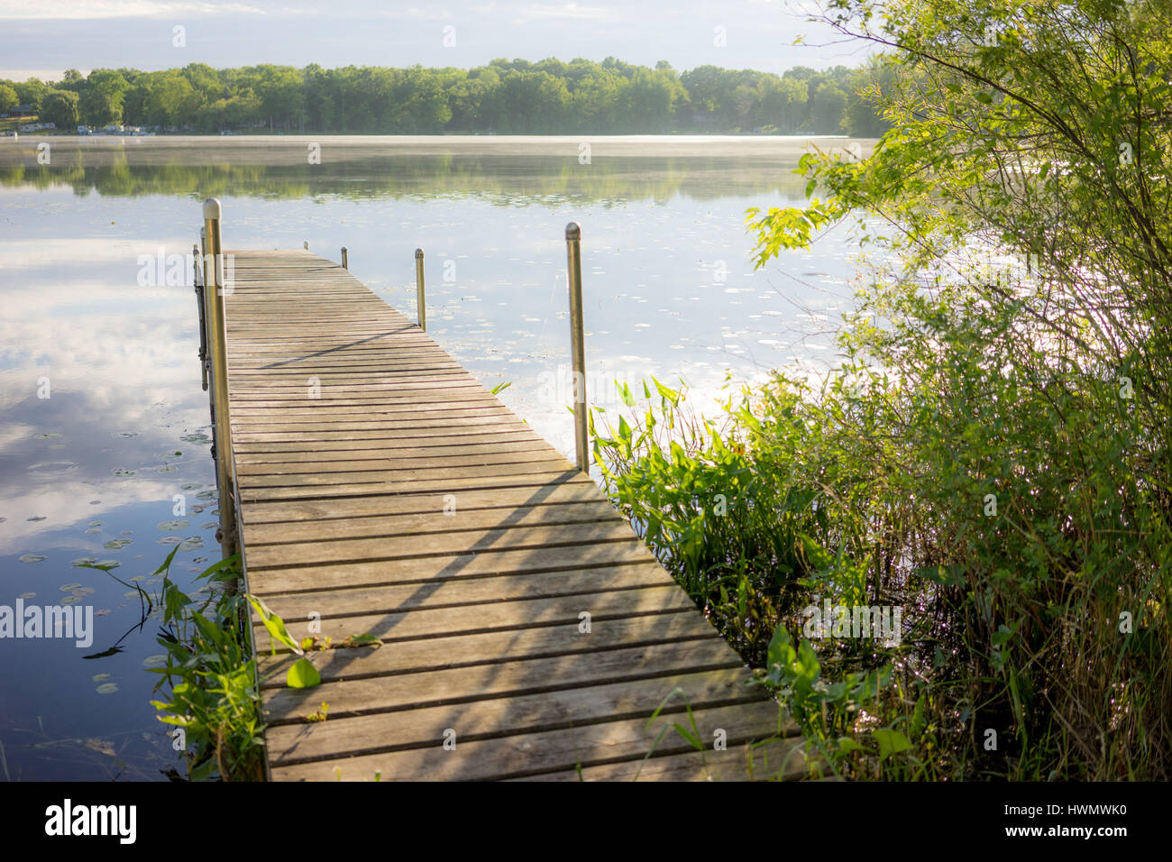 A well lit dock just out onto a serene lake in Brooklyn, Michigan Stock