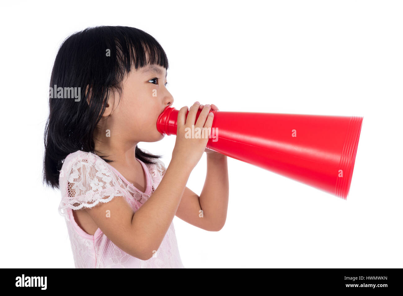 Asian Chinese little girl shouting with retro loudspeaker in isolated white background. Stock Photo