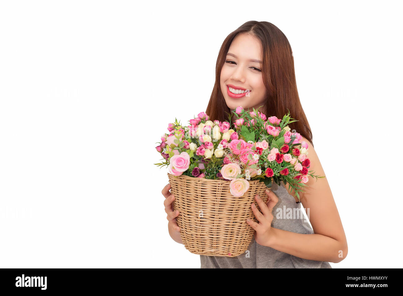 Girl holding a basket of flowers.  Isolated on white. Stock Photo