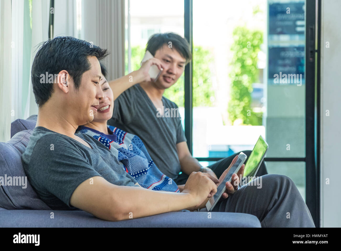 Group of people discussion by using mobile phone,tablet ,laptop computer at home,casual meeting,mobile office. Stock Photo
