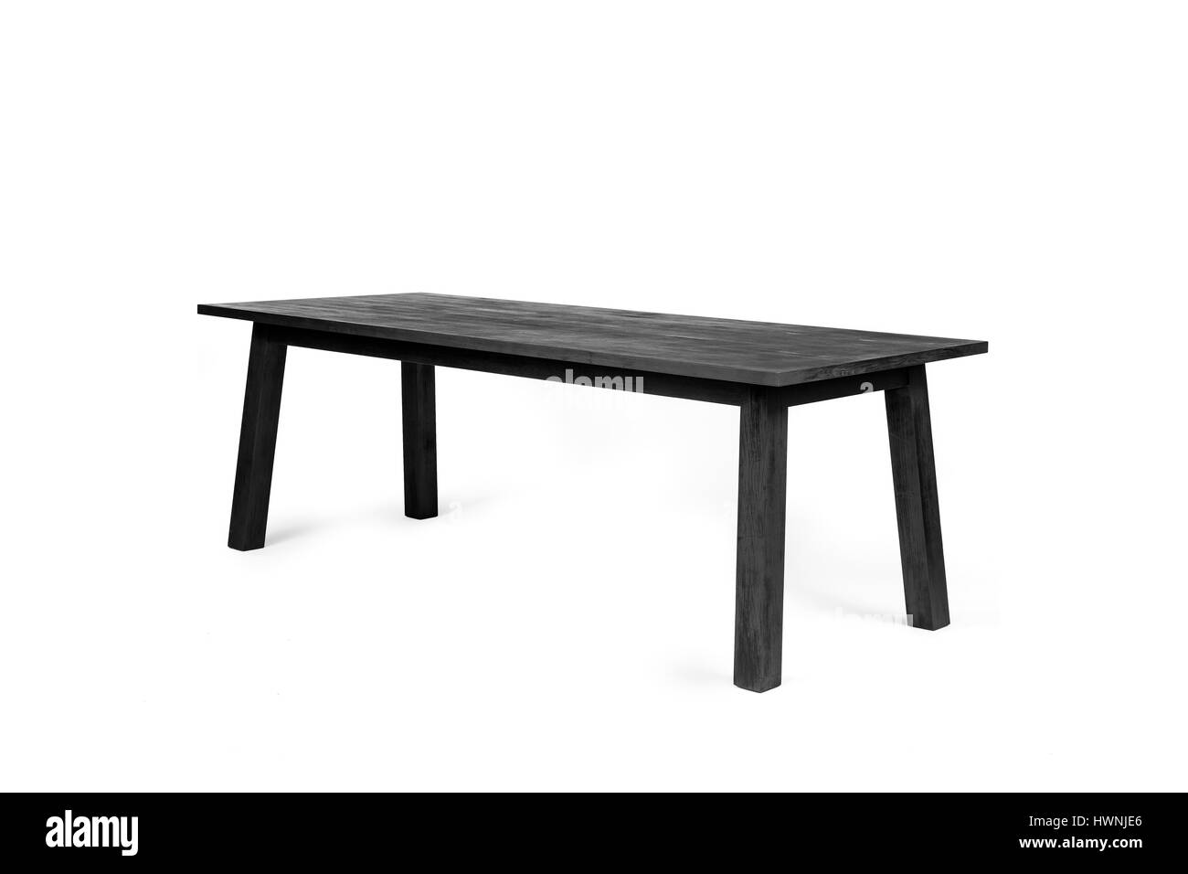 A contemporary table - made out of charred wood according the shou-sugi-ban technique - photographed on a white background. Stock Photo