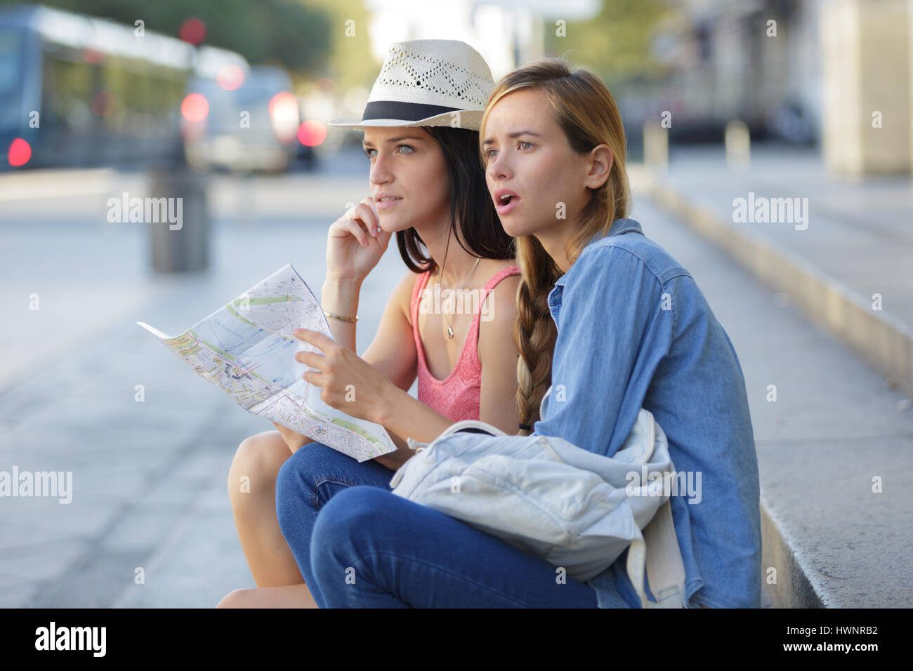 lost and confused girl friends looking for directions on map Stock Photo
