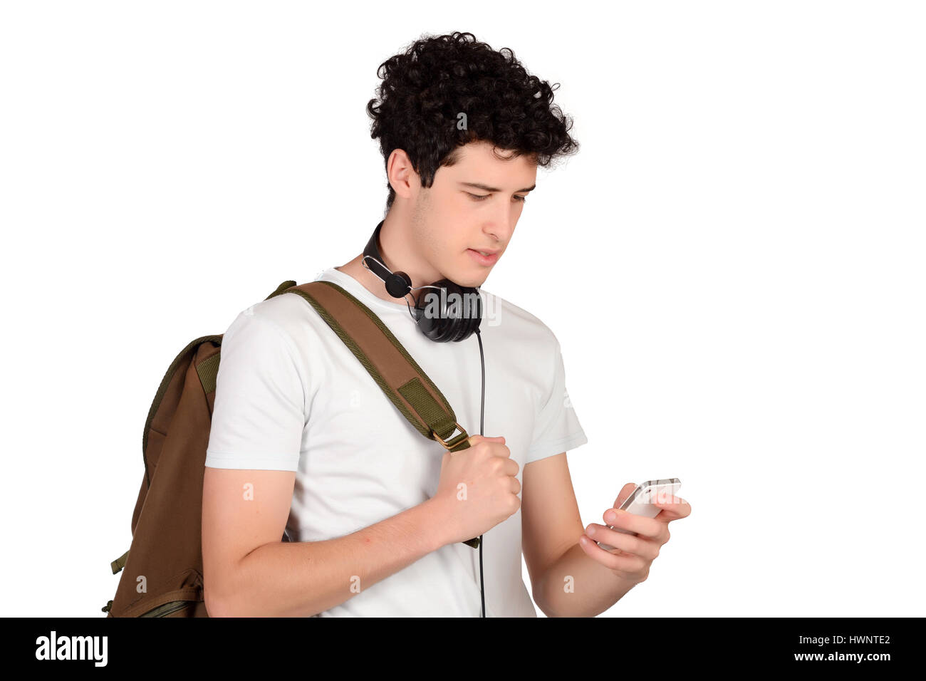 Portrait of young latin man with backpack and using his smartphone. Isolated white background