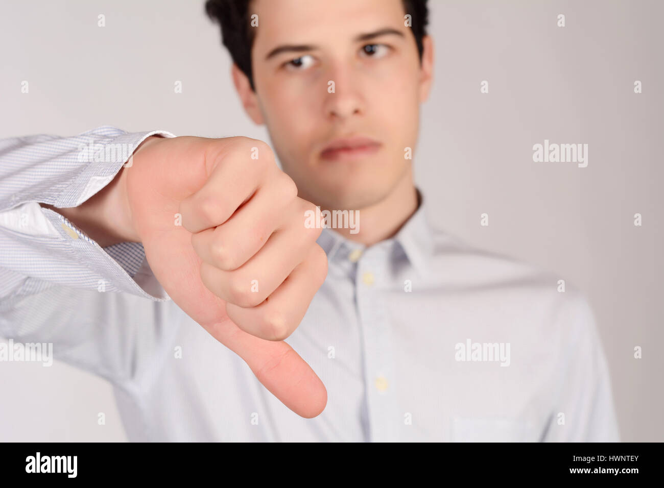 Portrait of young man with thumb down. Isolated white background Stock Photo Alamy