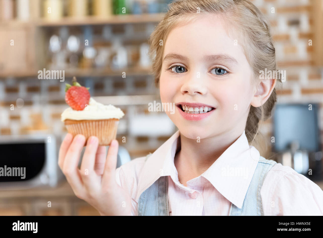 Happy little girl holding homemade cake and smiling at camera Stock ...