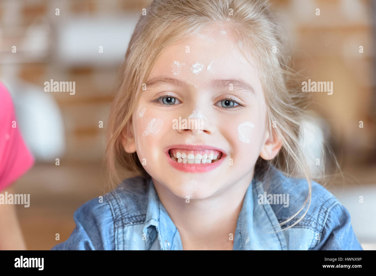 portrait of beautiful smiling girl with flour on face Stock Photo