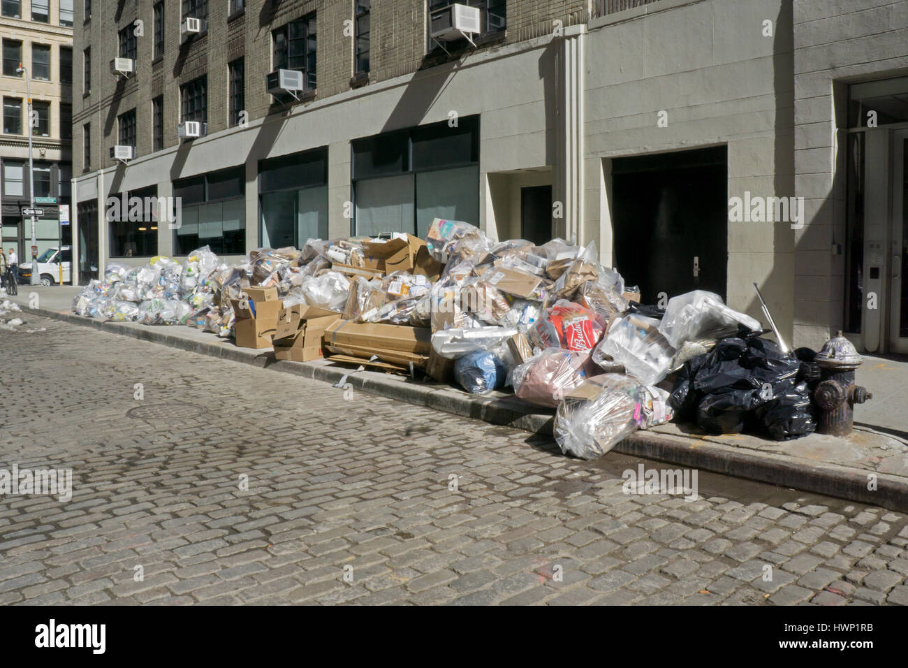 A huge pile of garbage bags awaiting collection on Greene Street in Greenwich Village, New York City. Stock Photo
