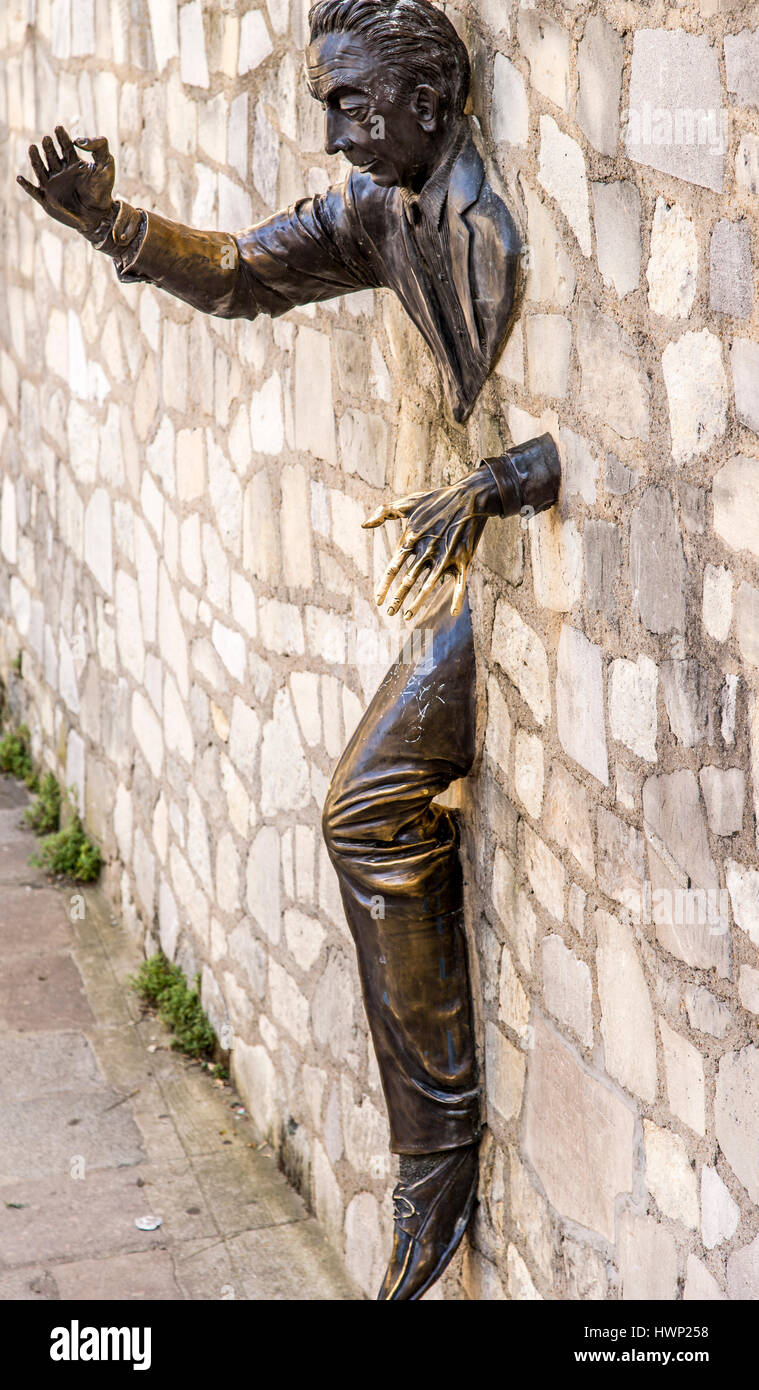 Le Passe-Muraille also known as Walker-Through-Walls sculpture located in a rue Norvins car park in Montmartre Paris France. Stock Photo