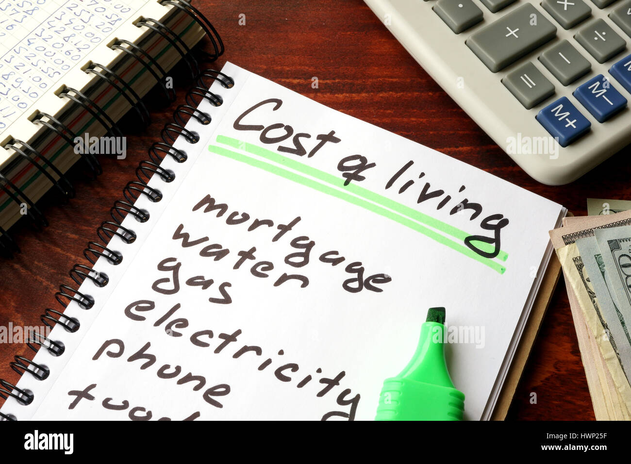 Cost of living written in a notebook and calculations of home finances. Stock Photo