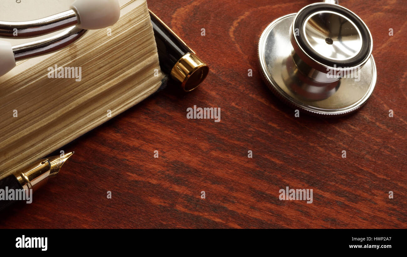Medical care concept. Stethoscope and book on a table. Stock Photo