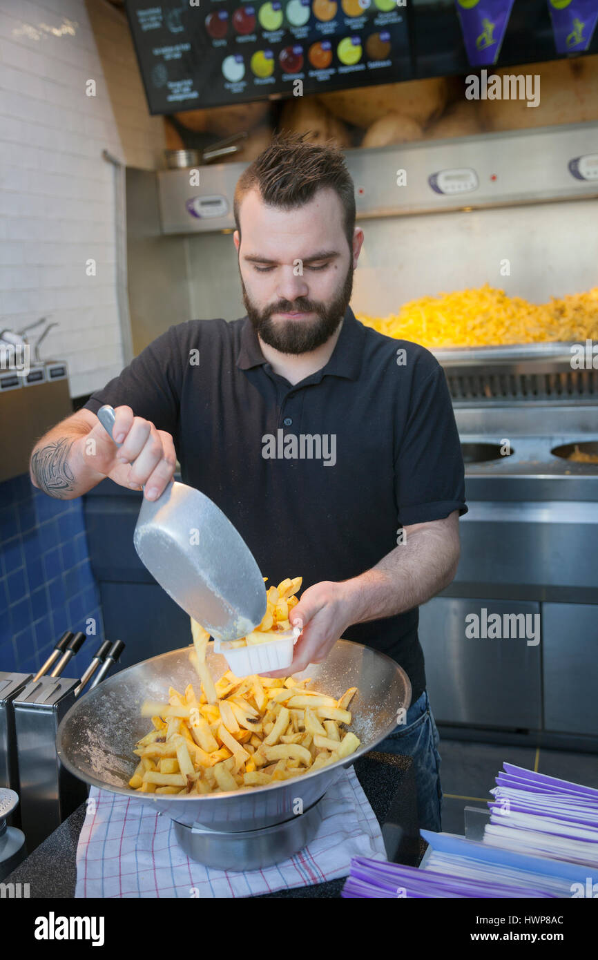 utrecht, netherlands, 15march 2017: young man with hipster beard makes and sells french fries in the netherlands Stock Photo