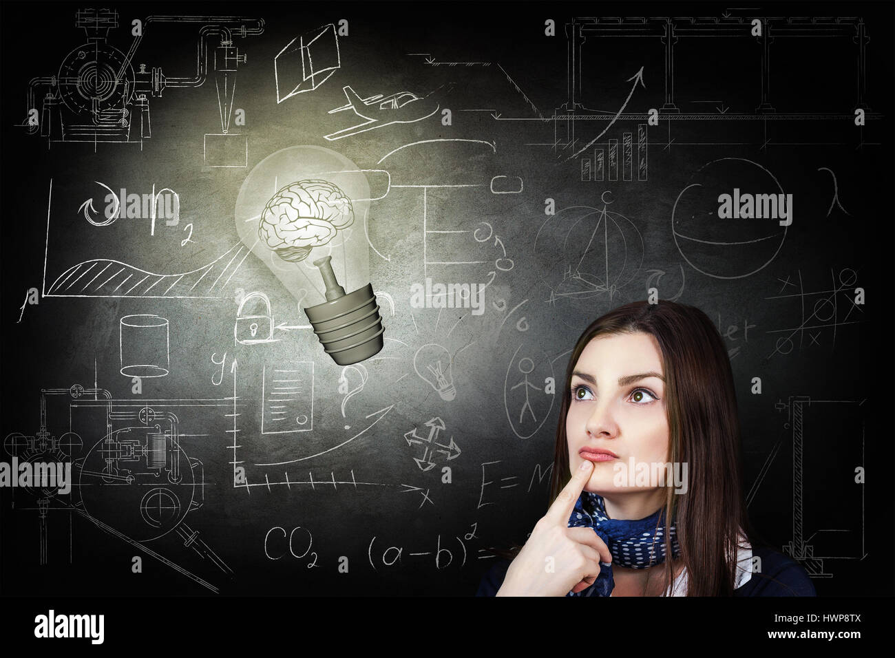 Thoughtful woman looking at bright bulb over icons on chalk board Stock Photo