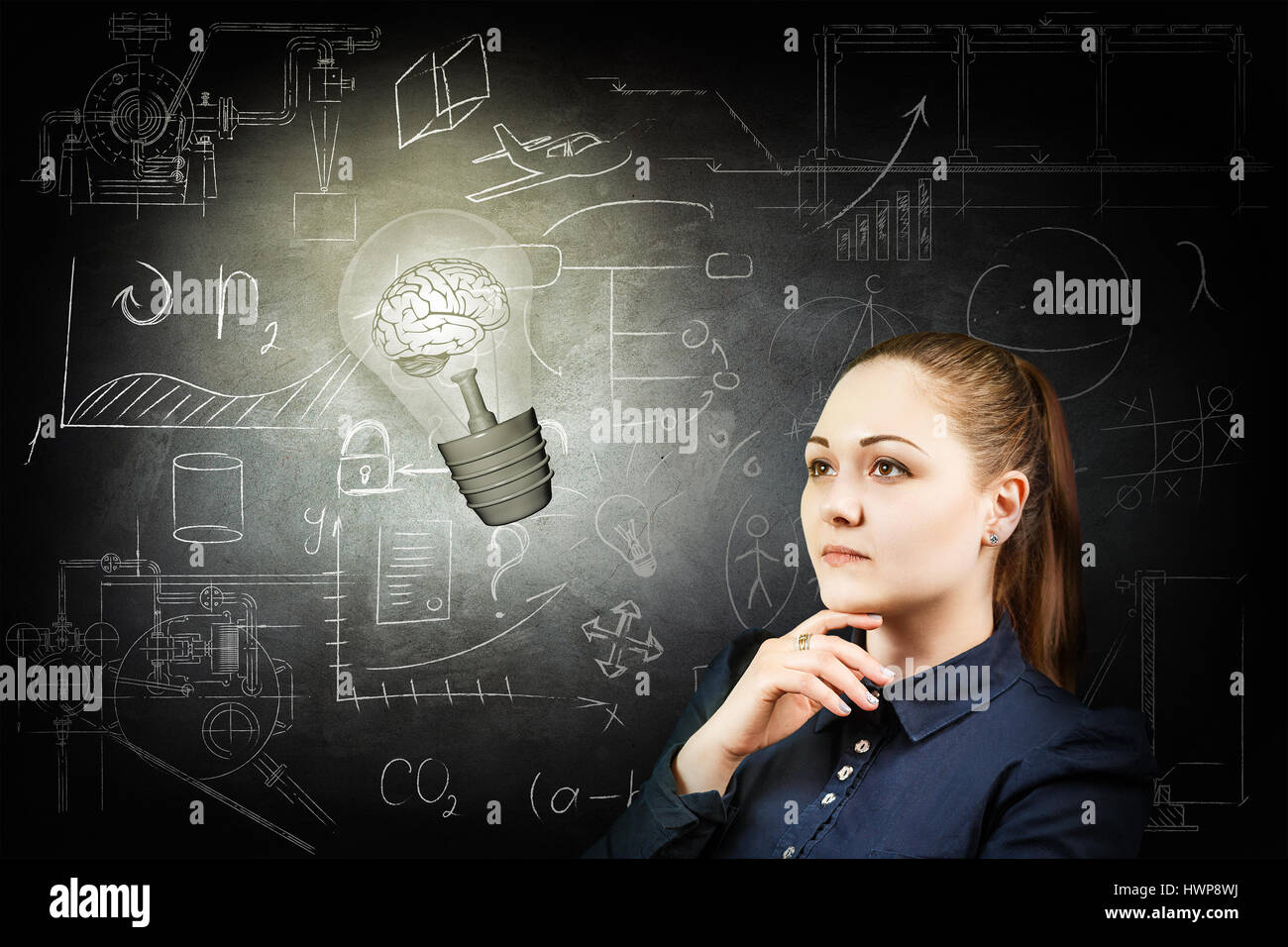 Thoughtful woman looking at bright bulb over icons on chalk board Stock Photo