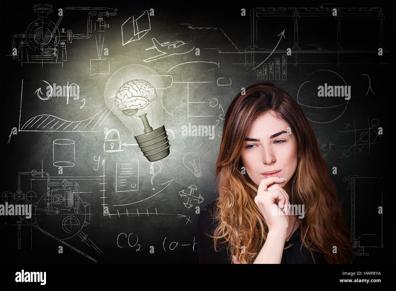 Thoughtful woman near bright bulb over icons on chalk board Stock Photo