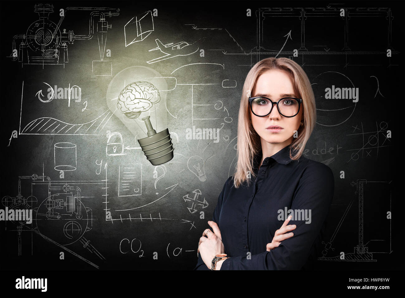 Thoughtful woman near bright bulb over icons on chalk board Stock Photo