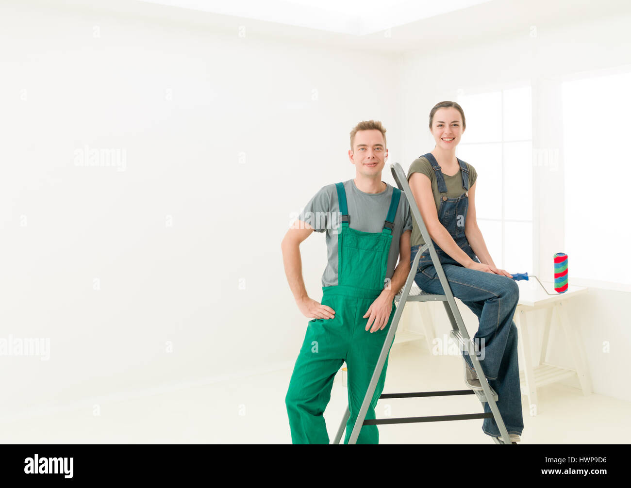 man and woman couple ready to decorate home. bright white interior ...