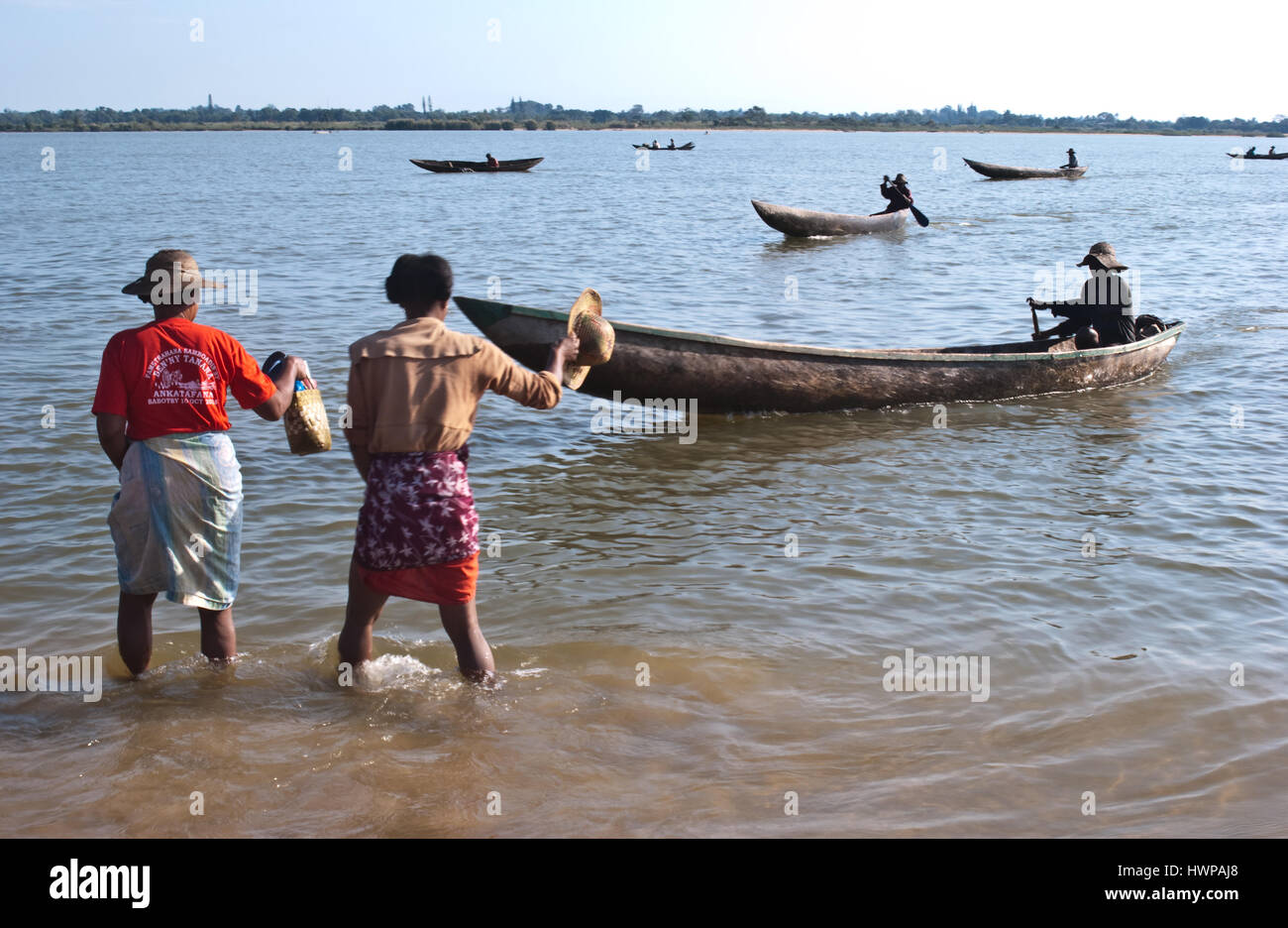 Two women are hailing a taxi boat to cross the lake ( Madagascar) Stock Photo