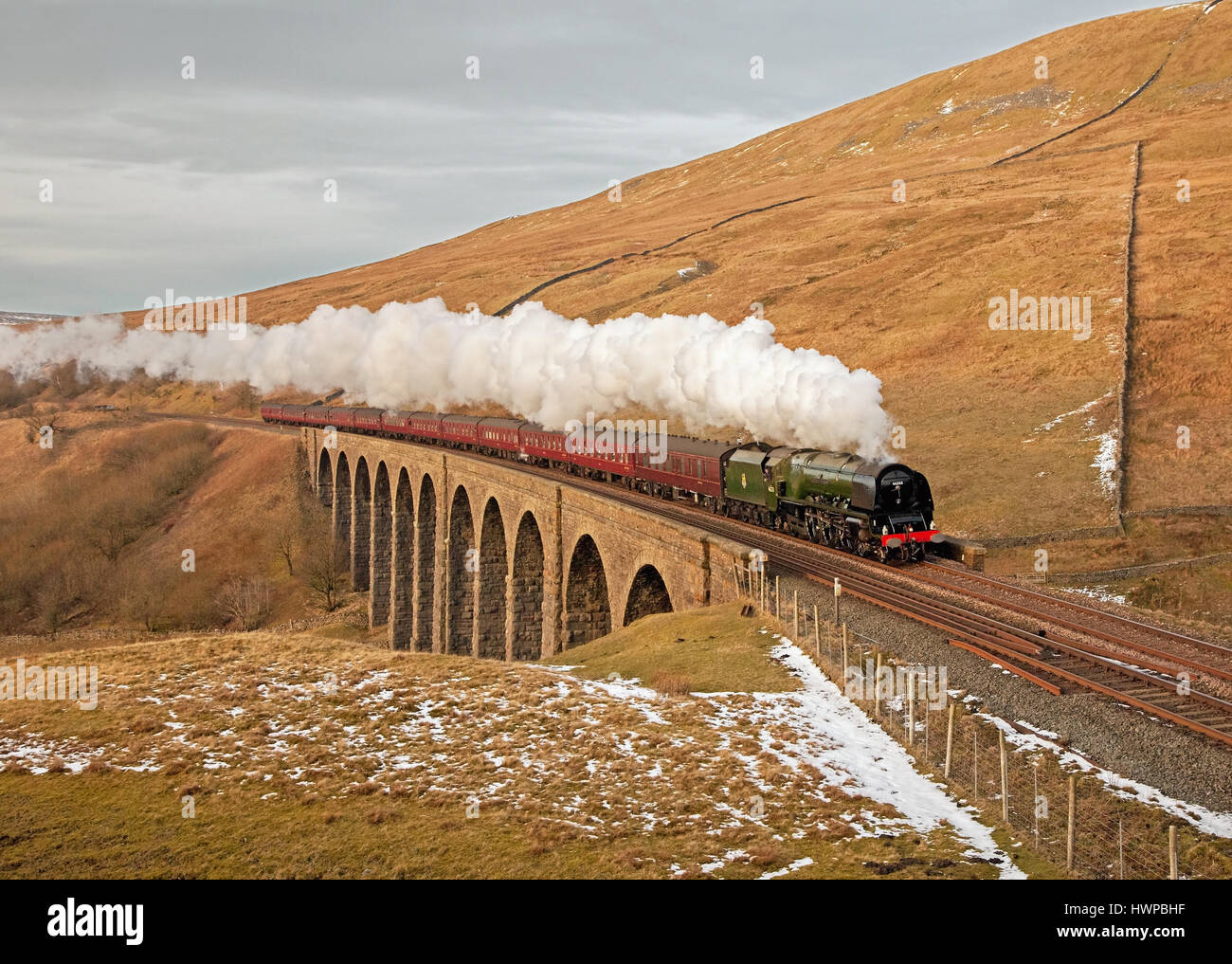 46233 Duchess of Sutherland heads over Arten Gill Viaduct, with a Winter Cumbrian Mountain on 7 February 2015. Stock Photo