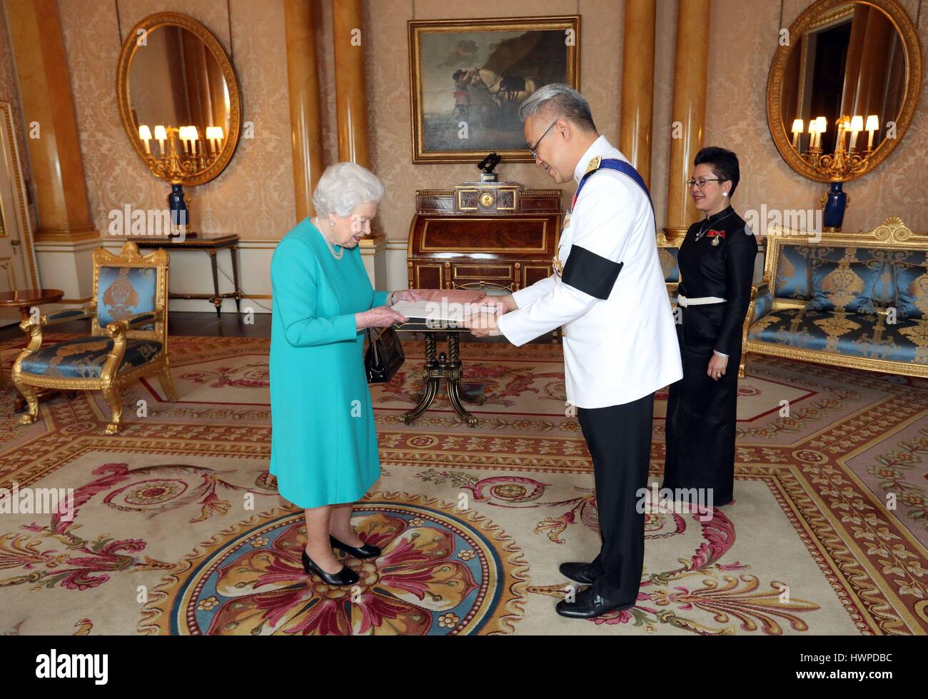 Queen Elizabeth II (left) is presented with Letters of Credence by the  Ambassador from the Kingdom of Thailand, Mr. Pisanu Suvanajata (centre),  accompanied by his wife, Mrs. Thipayasuda Suvanajata (right), during a