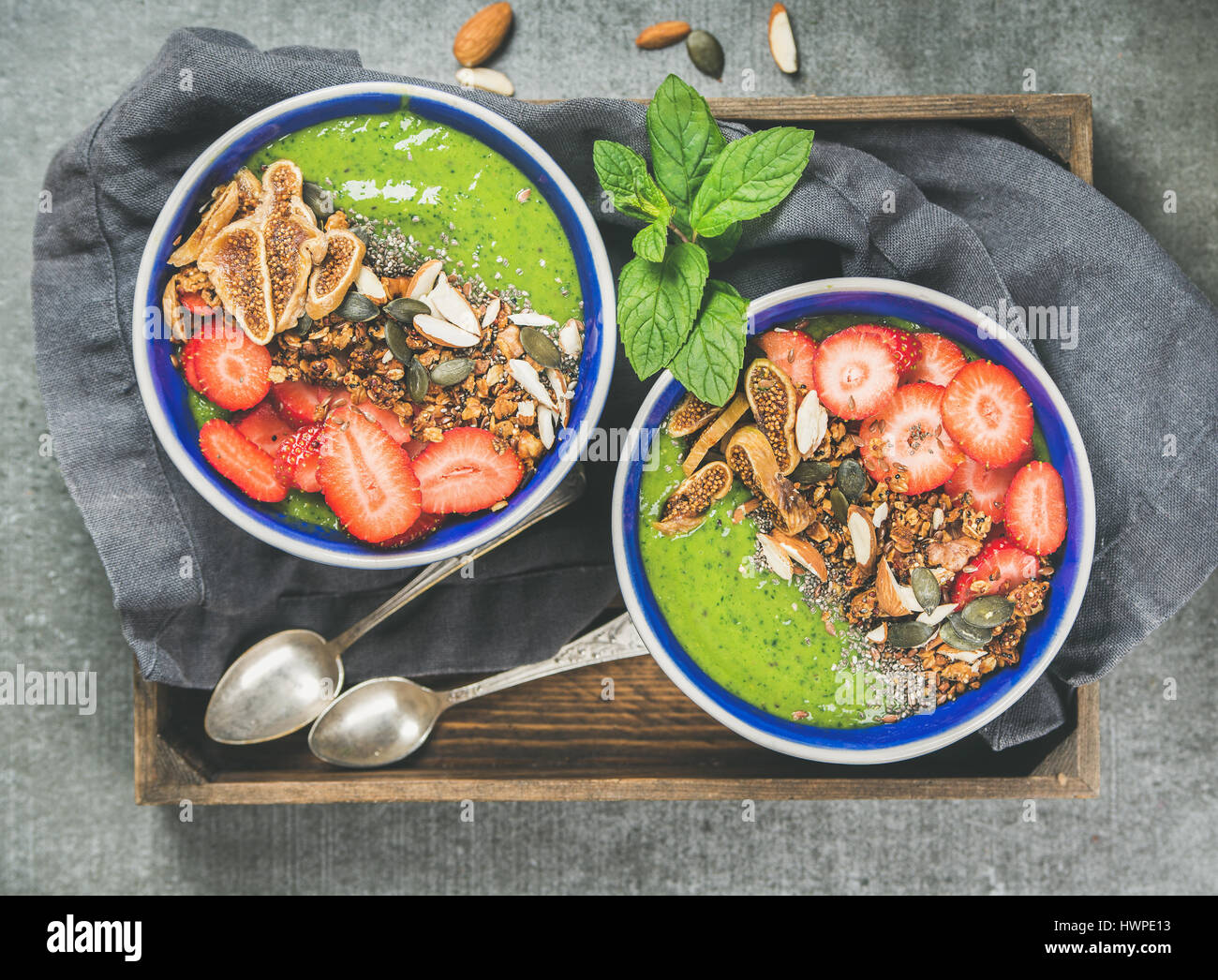 Healthy green smoothie breakfast bowls with granola, fruit, seeds ...