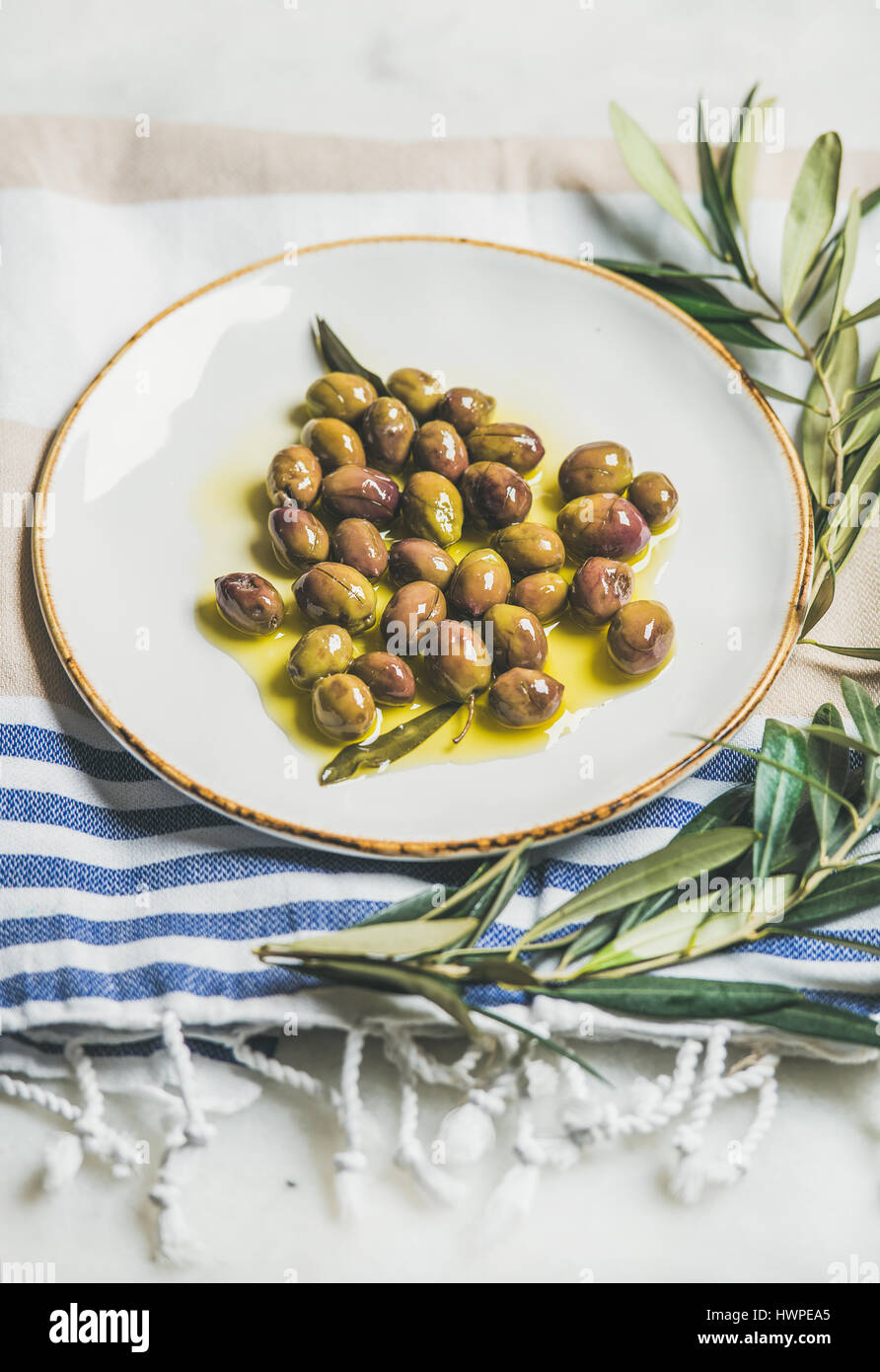 Pickled green Mediterranean olives and olive tree branch Stock Photo