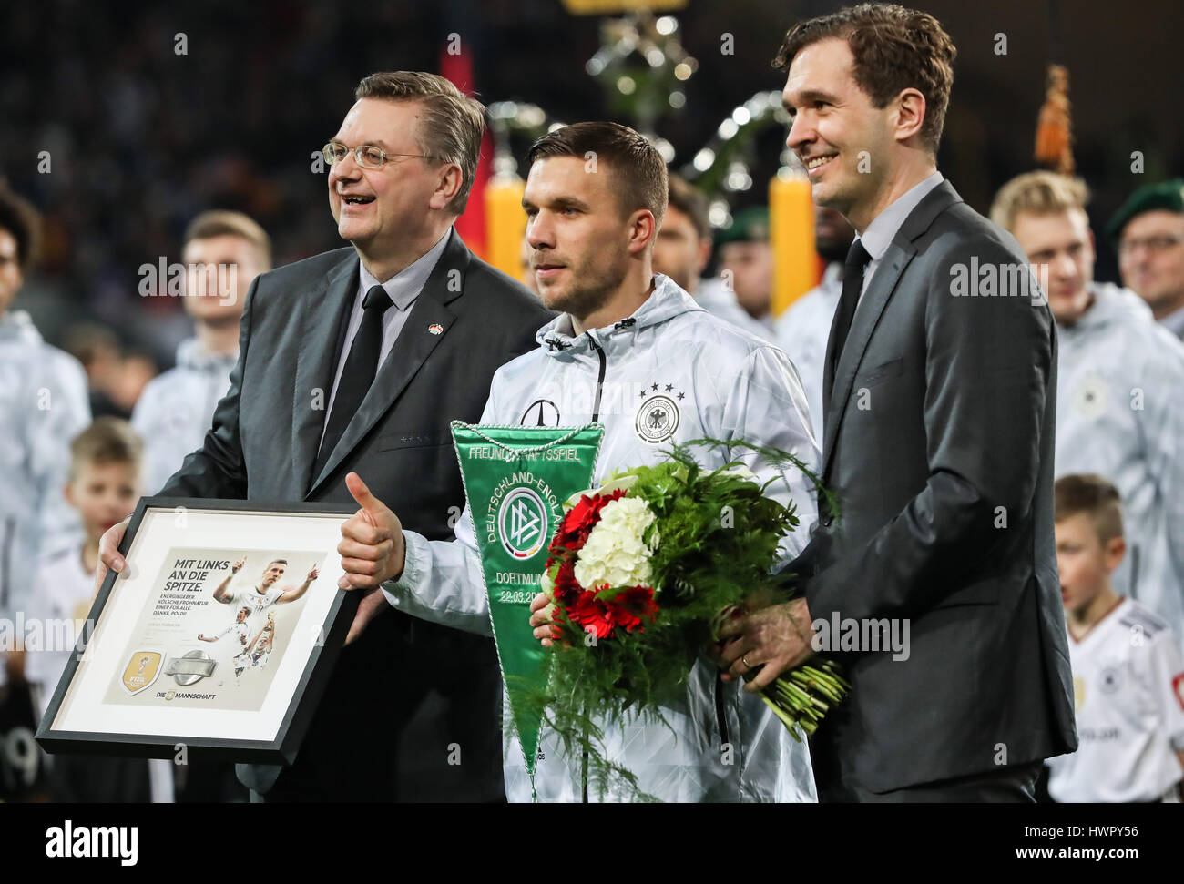 Dortmund, Germany. 22nd Mar, 2017. Germany's Lukas Podolski (C) receives an award from German Football Association before an international friendly match between Germany and England in Dortmund, Germany, on March 22, 2017. Germany won 1-0 and Germany's Lukas Podolski retired from German national team after this match. Credit: Shan Yuqi/Xinhua/Alamy Live News Stock Photo