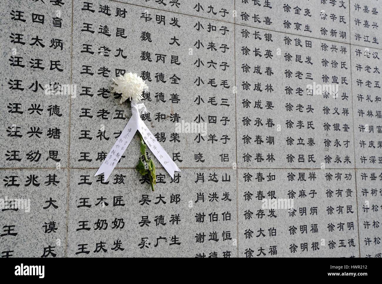 Nanjing, China's Jiangsu Province. 4th Apr, 2017. A paper flower is seen on the wall remembering the victims at the Memorial Hall of the Victims in Nanjing Massacre by Japanese Invaders in Nanjing, capital of east China's Jiangsu Province, April 4, 2017. A mourning ceremony was held here by survivors and family members of victims in the Nanjing Massacre during Tomb-Sweeping Day, or Qingming, when Chinese people commemorate their deceased loved ones by visiting tombs. Credit: Han Yuqing/Xinhua/Alamy Live News Stock Photo