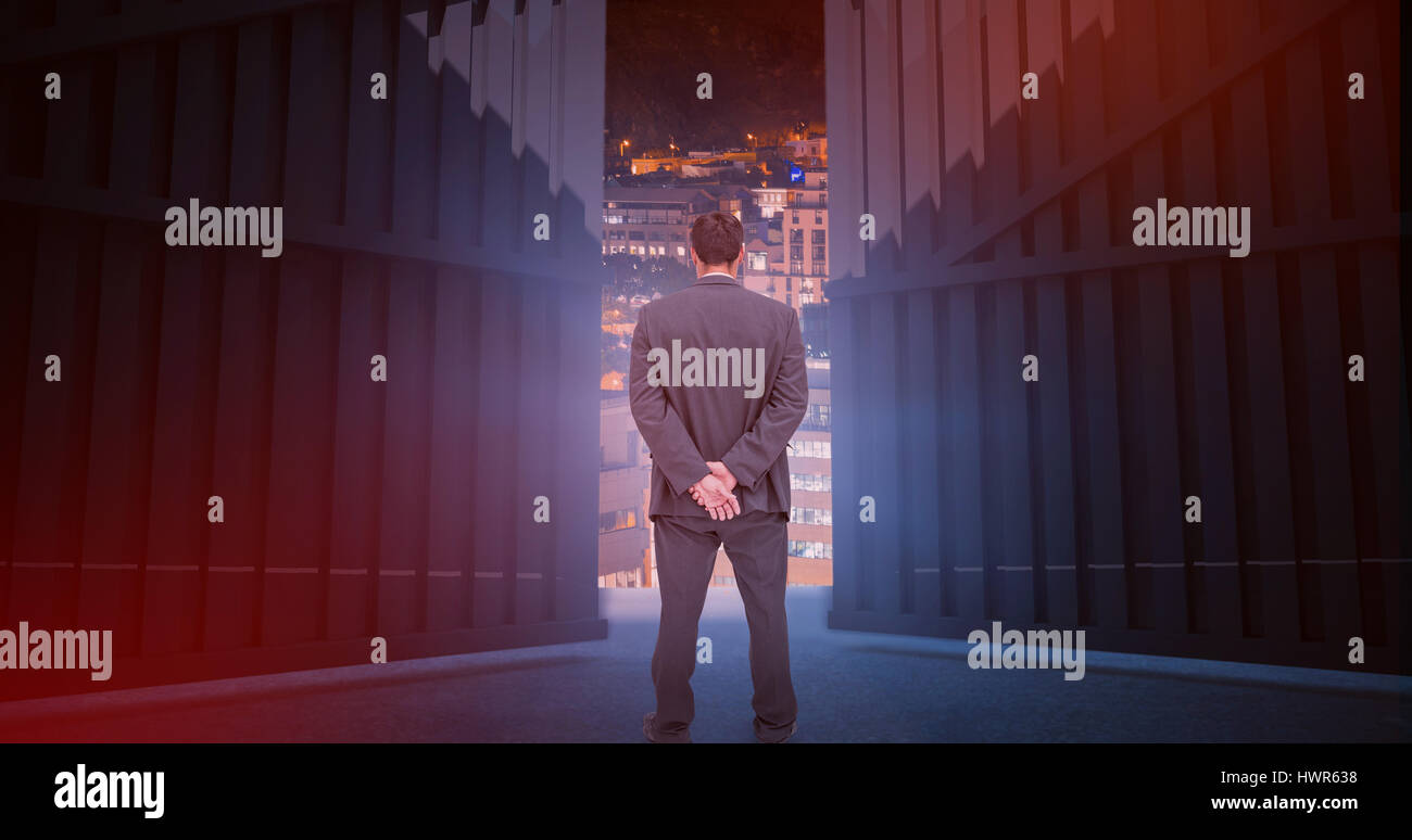 Rear view of classy businessman posing against glowing modern buildings in city 3d Stock Photo