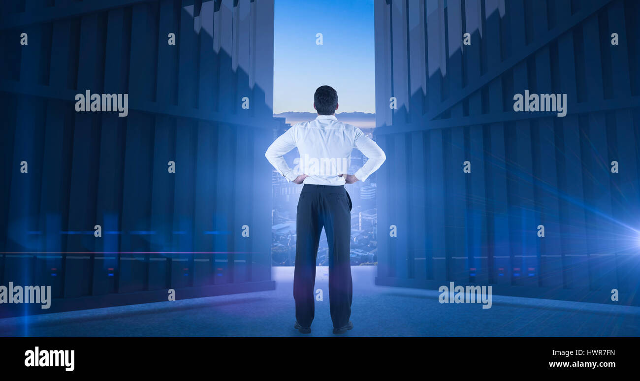 Businessman standing back to the camera with hands on hips against beautiful view of city skyline 3d Stock Photo
