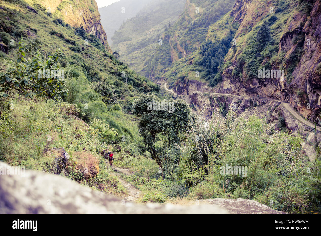 Female backpacker climbing with backpack in Himalayas, Nepal. Trekking