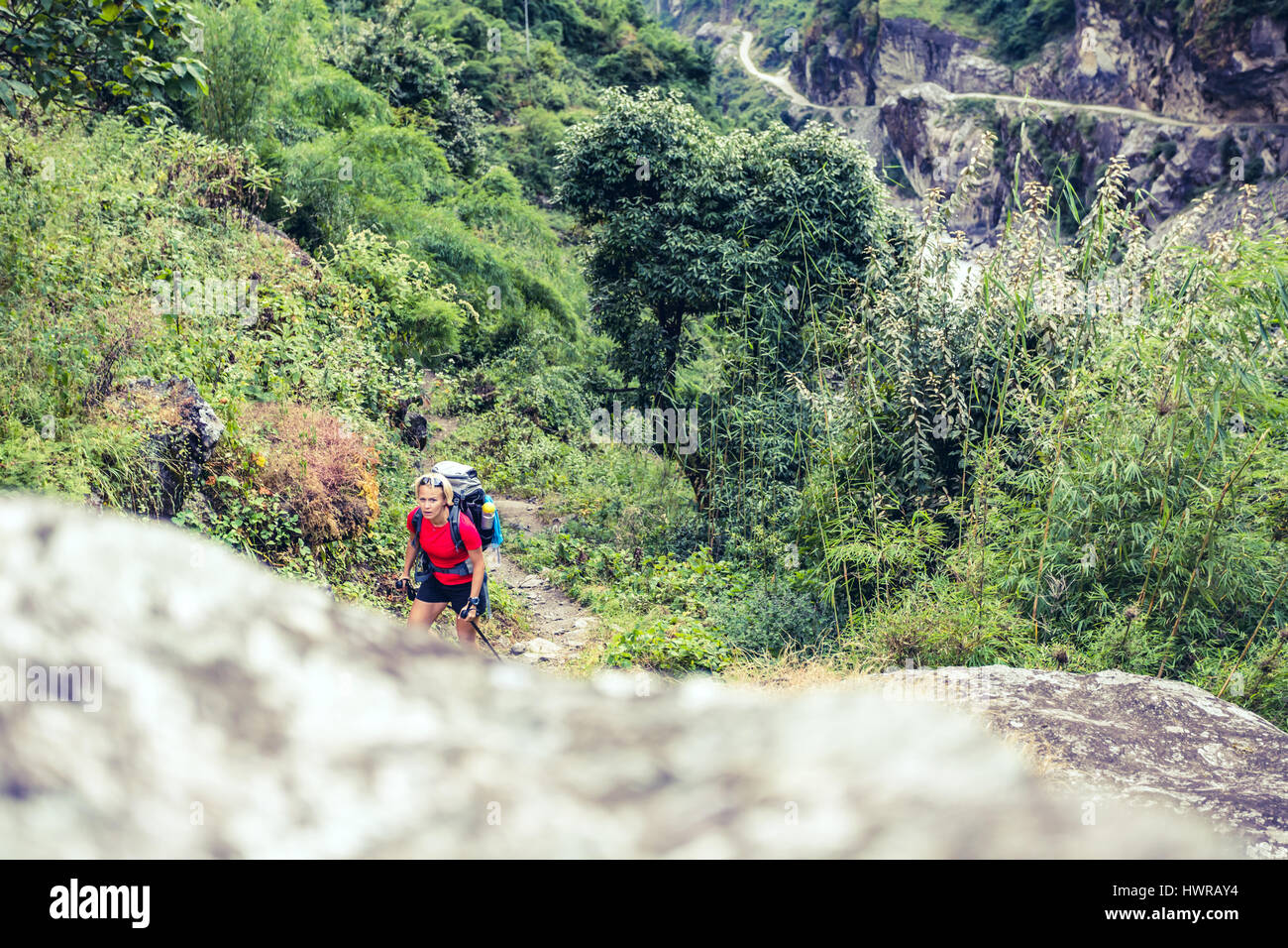 Woman backpacker climbing with backpack in Himalayas, Nepal. Trekking