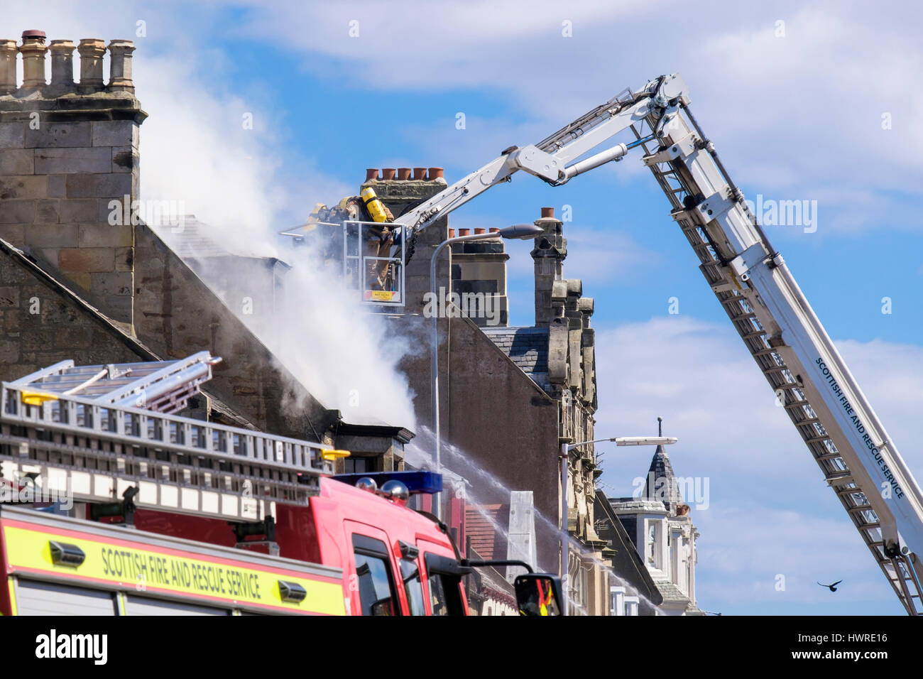 Scottish Fire and Rescue Service firefighters up a ladder fighting a blazing building. Elie and Earlsferry, Fife, Scotland, UK, Britain, Europe Stock Photo
