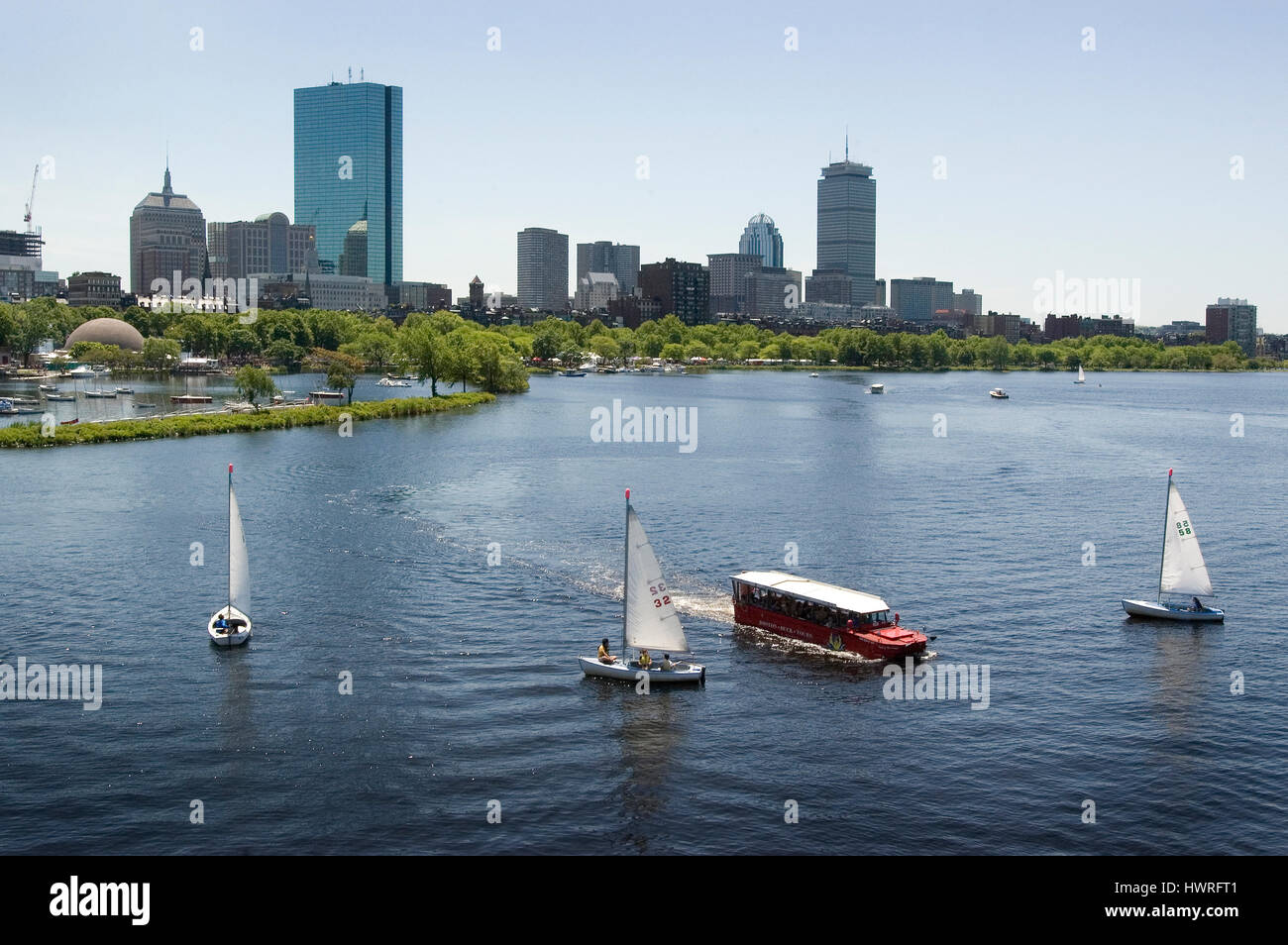 The Back Bay skyline and the Charles River from the Longfellow Bridge - Community Boating Sailboats and a Duck Tour boat are in the foreground, Stock Photo