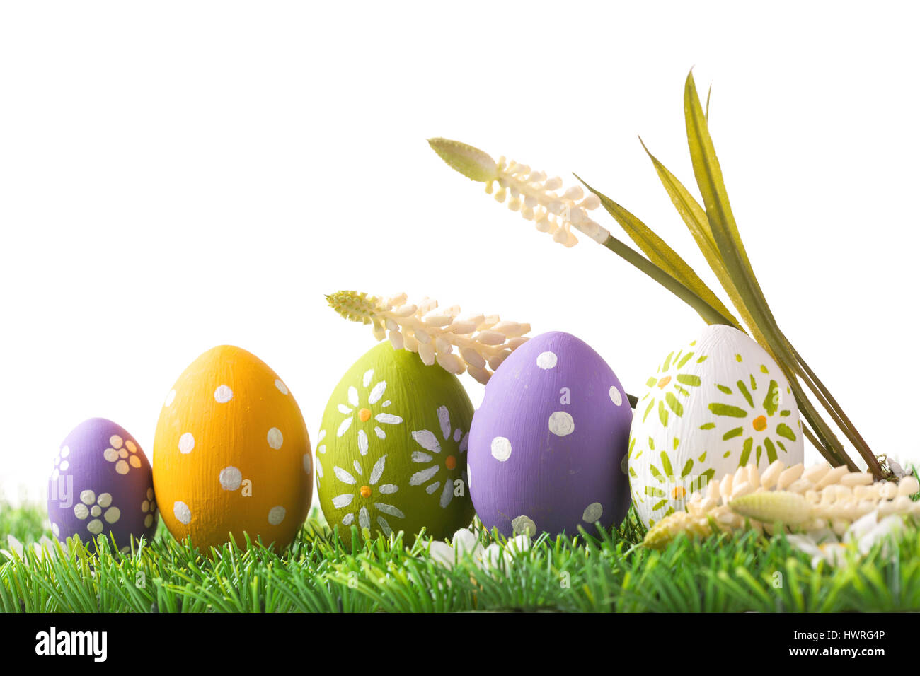 Bunch of easter eggs in pastel colors on grass, isolated on white background Stock Photo