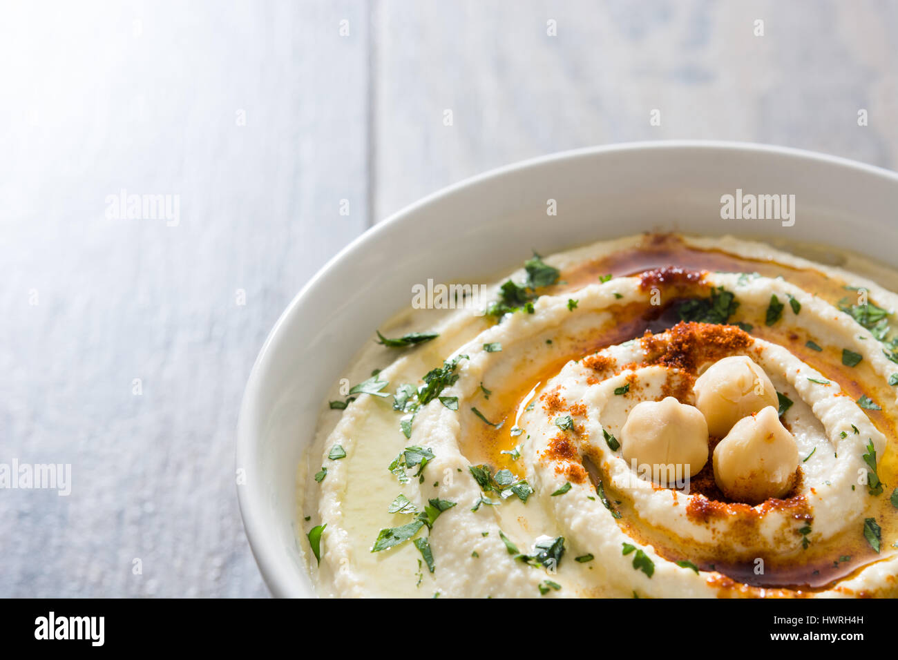 Hummus on a rustic wooden table Stock Photo - Alamy