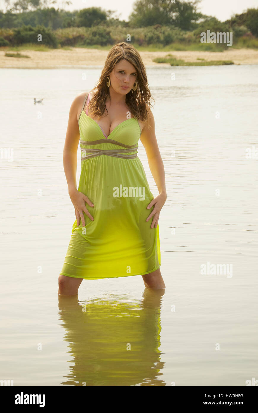 Beautiful young woman on the beach wearing a lime green summer dress Stock Photo