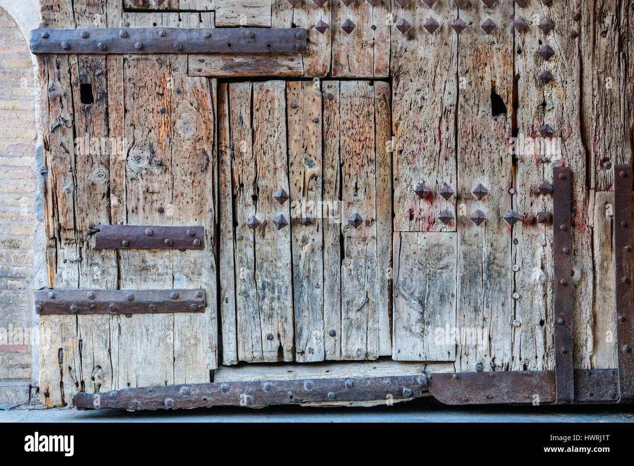 Old weathered wooden gate of Torres de Serranos with wicket gate. Valencia, Spain. Stock Photo