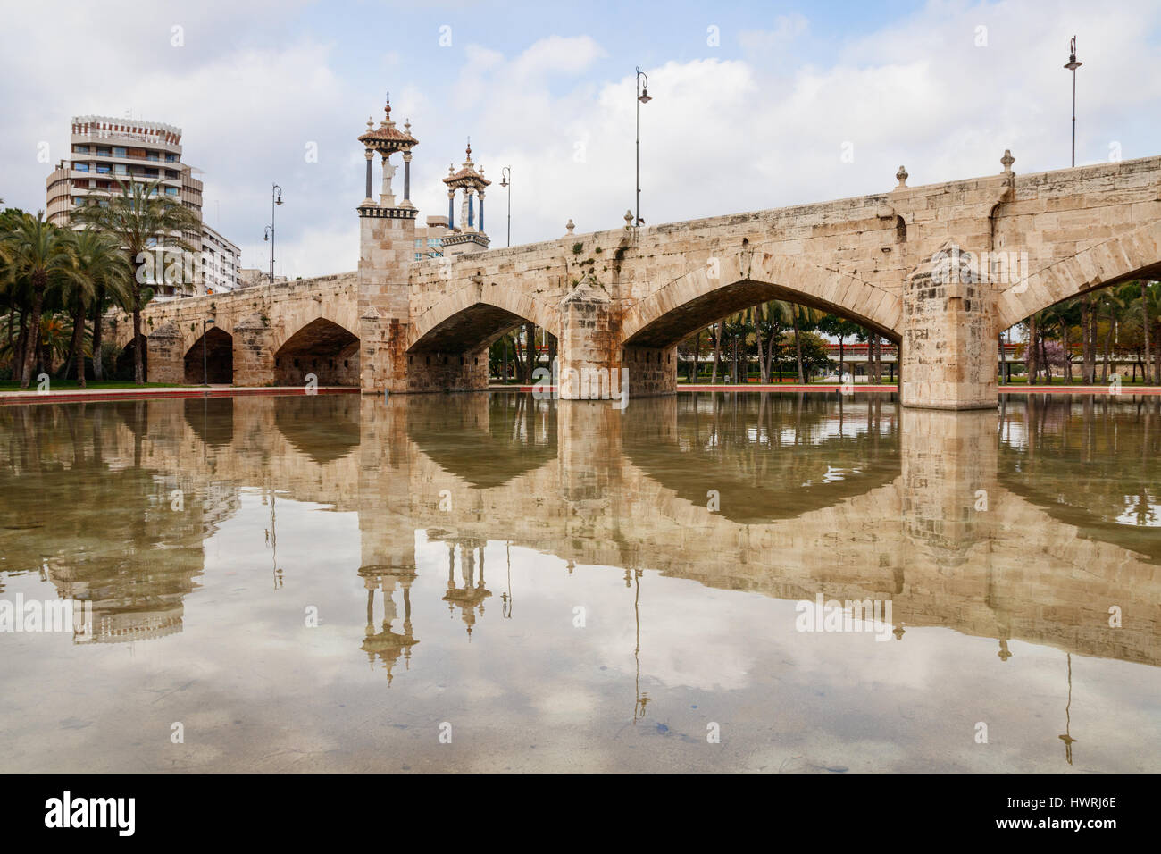 The Pont del Real and its reflection in a small pond of the Jardin del Turia (Turia Gardens) under a cloudy sky. Valencia, Spain. Stock Photo