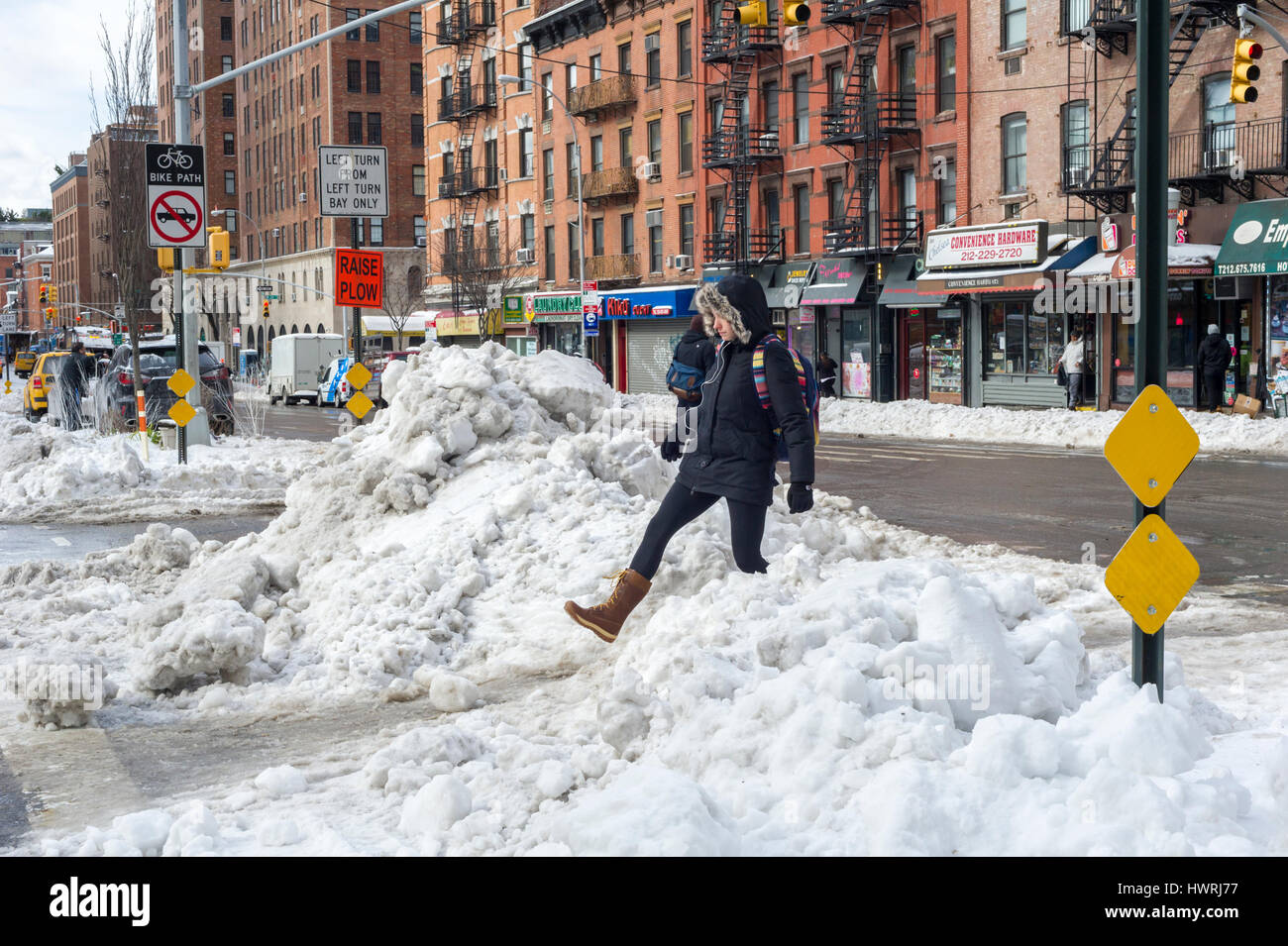 Pedestrians attempt to maneuver tiny pathways in the snow without falling into the banks of frozen snow at crossings in the Chelsea neighborhood of New York on Wednesday, March 15, 2017 after Winter Storm Stella deposited 7.2 inches in Central Park.  (© Richard B. Levine) Stock Photo