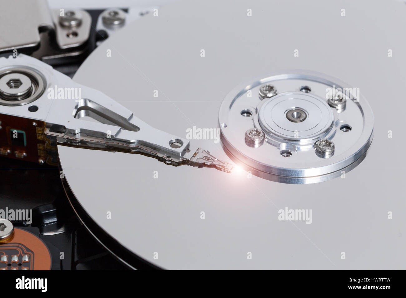 Open hard drive with magnetic disk and writing head. Stock Photo