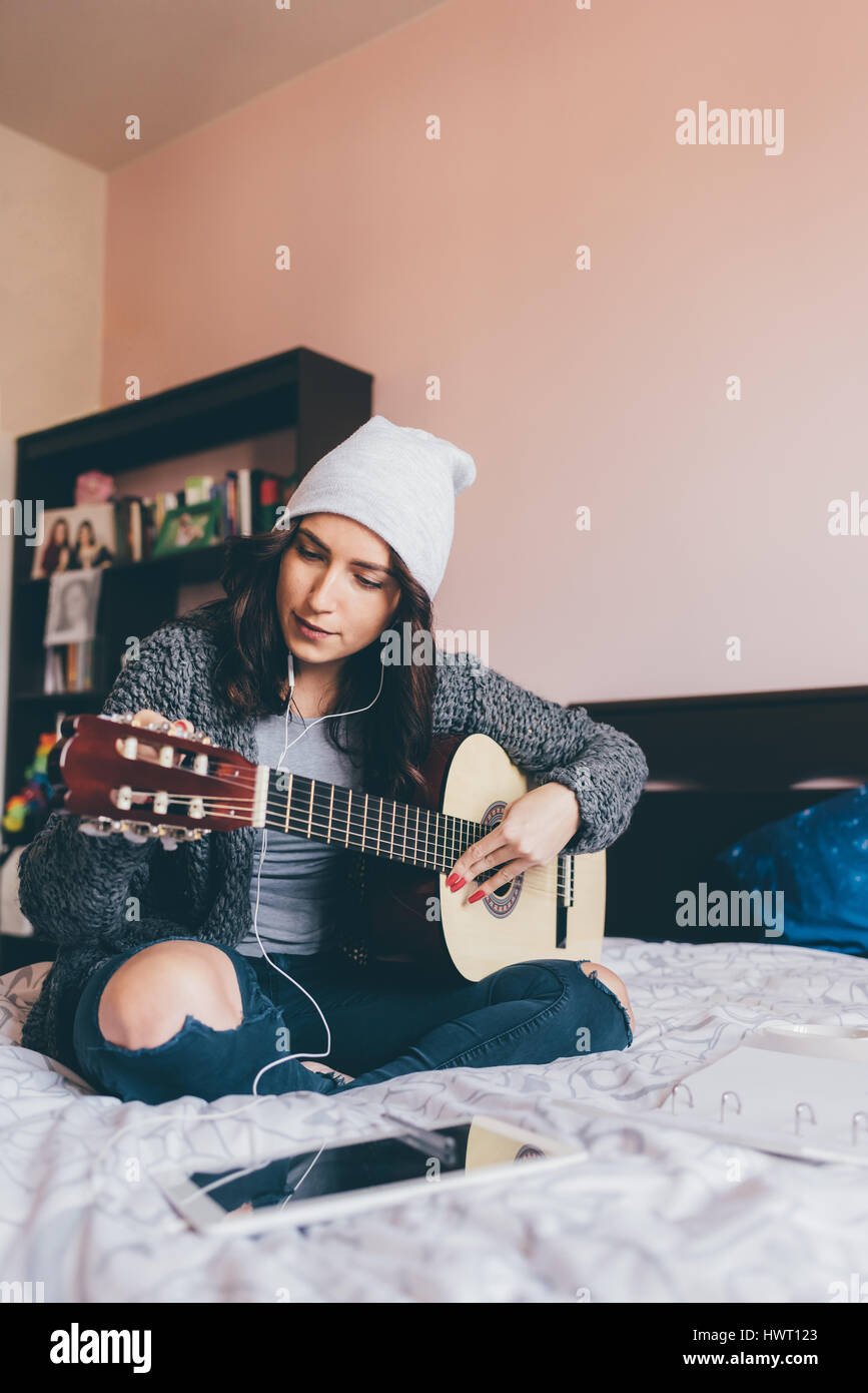 Young Beautiful Woman Composing A Song Sitting On Her Bed In