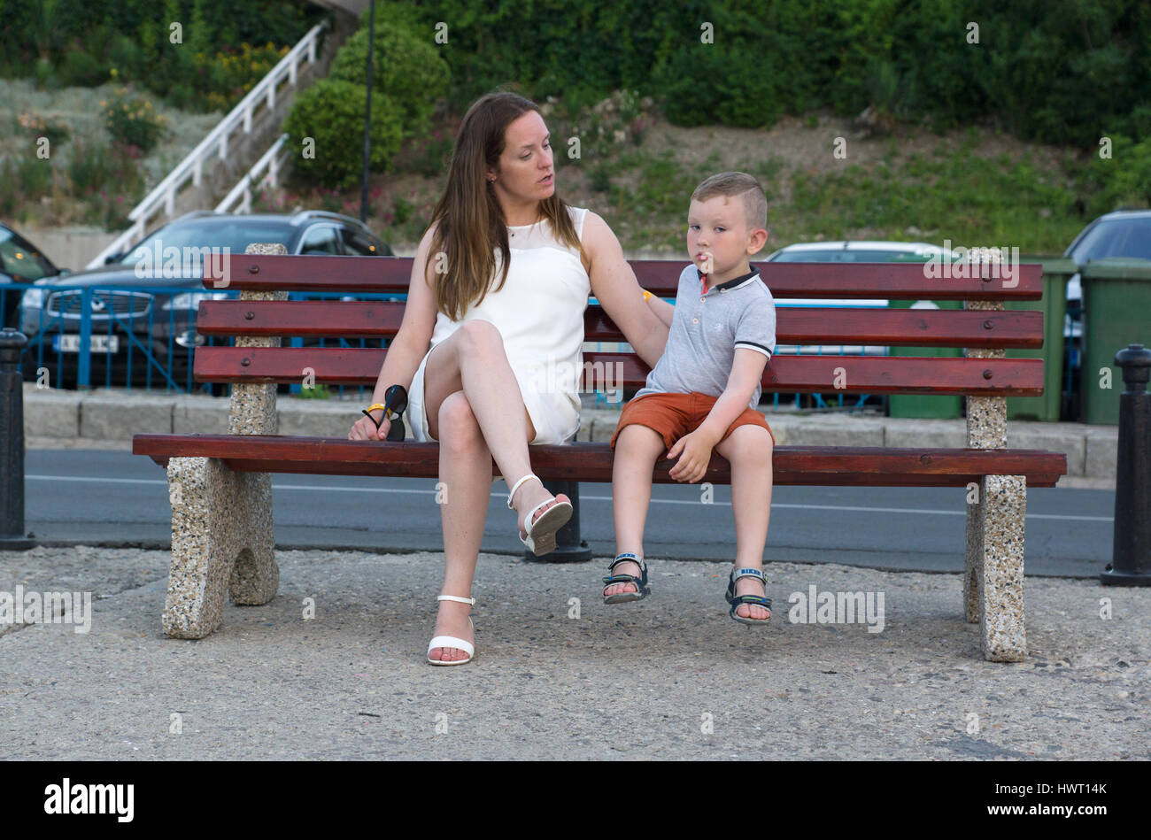 young woman talks with a child sitting on the bench Stock Photo Alamy
