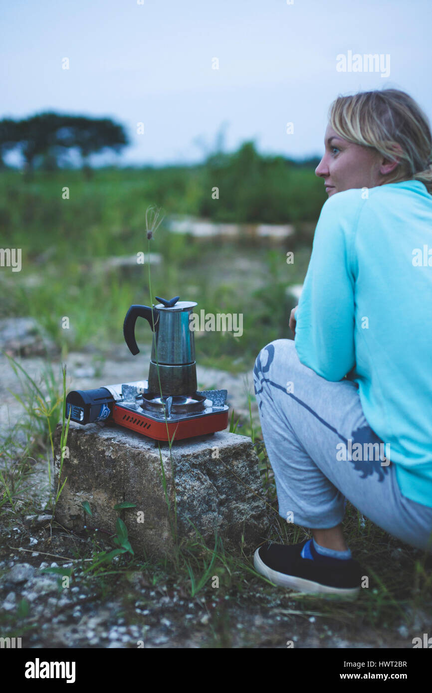 Woman looking away while preparing food on camping stove Stock Photo