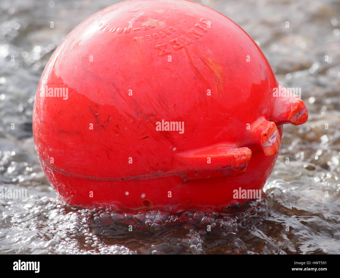 Red round bouy floating on the sea in Dorset,UK Stock Photo
